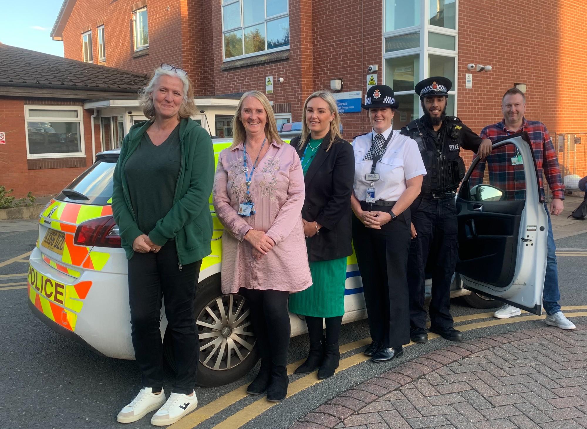CAMHS joint response colleagues with a police car outside the Irwell Unit at Fairfield General Hospital