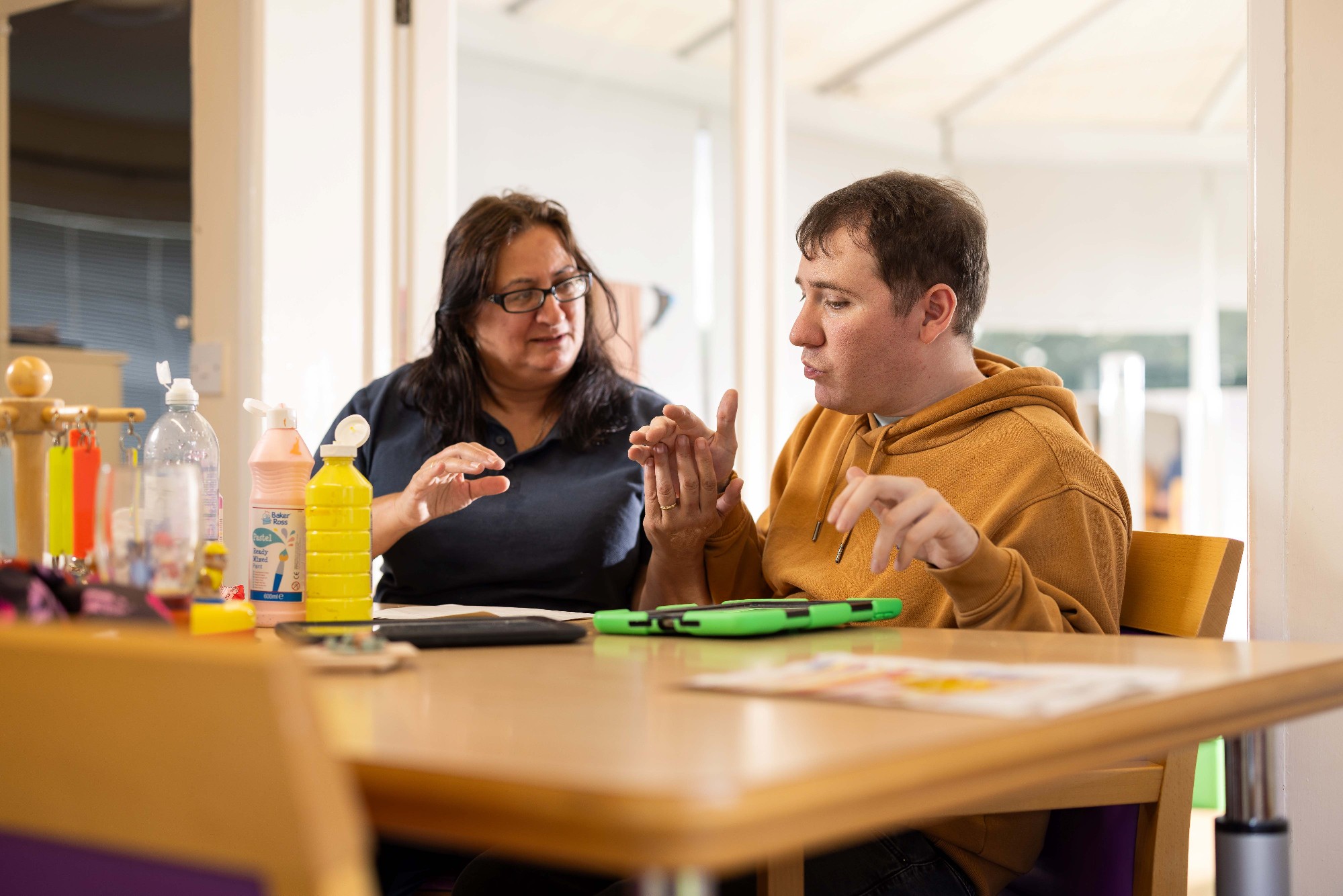 Pictured is service user Owen Philp enjoying a craft activity with senior support worker Nikki Whittaker 