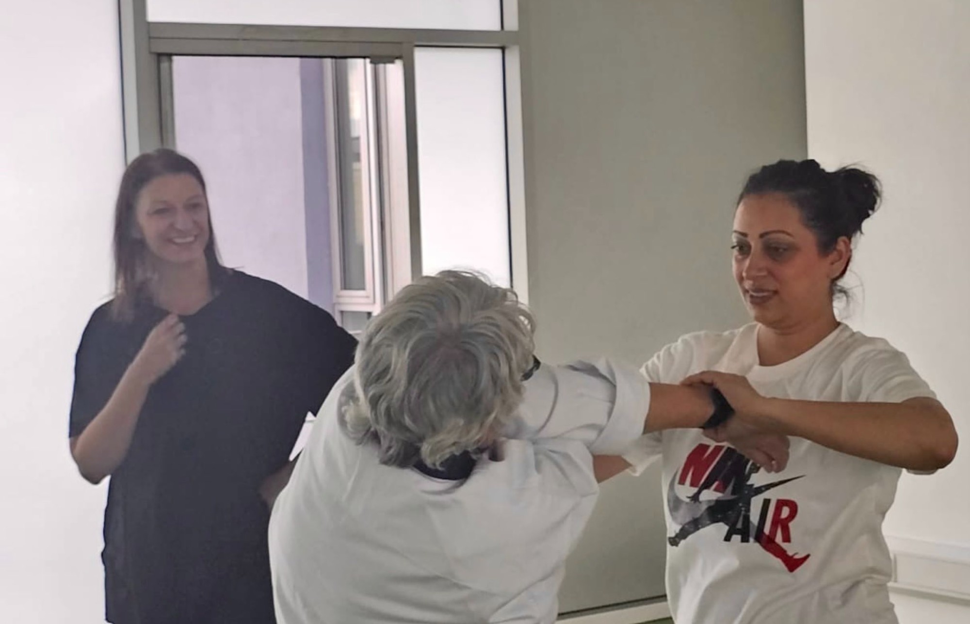 Lynn teaching a self-defence move to a lady as another looks on.jpg