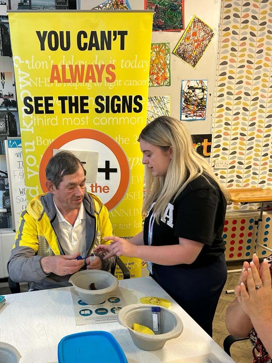A man and woman learning how to do a bowel screening test