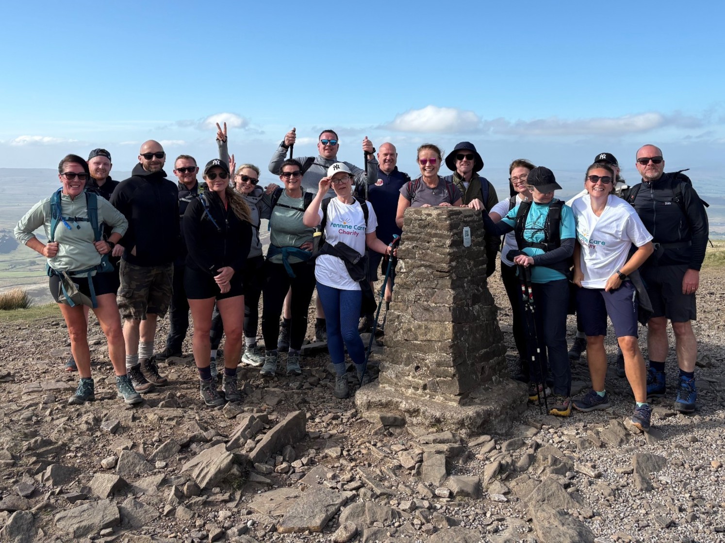 A large group of people at the summit of a hill, taking on the Three Peaks challenge.jpg