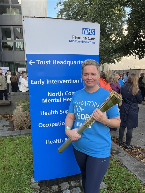 Tasha with the baton of hope outside Pennine Care NHS HQ.jpg